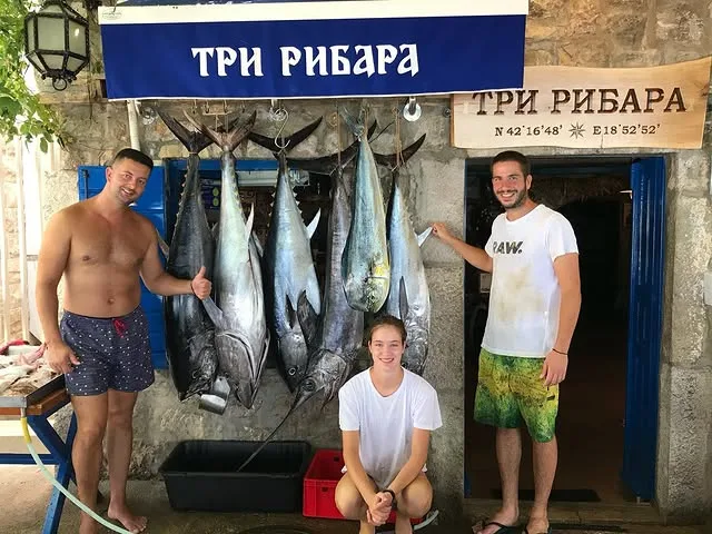 Porodica ispred restorana sa dnevnim ulovom tune