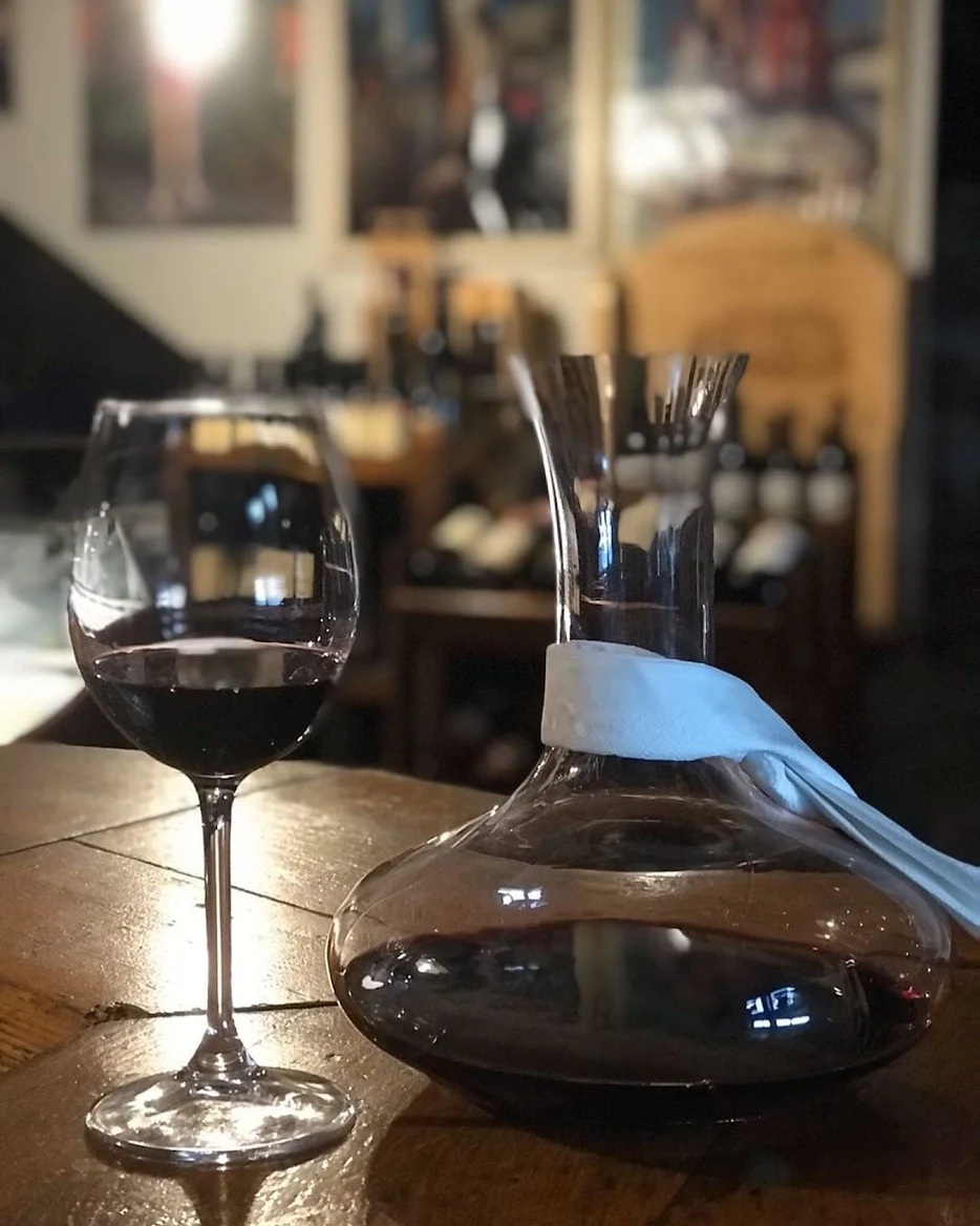Dekanter i čaša crnog vina u toploj večernjoj atmosferi